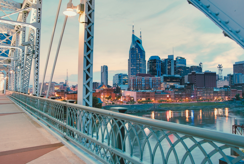 Image is of the Nashville skyline from the view of a bridge, concept of things to do in Nashville in September