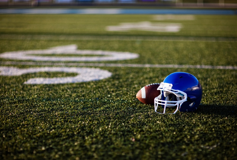 Image is of a blue football helmet sitting on a football field, concept of Tennessee Titans game weekend