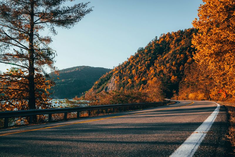 Image is of a curving mountain road during Autumn in Tennessee, concept of outdoor fall adventures in Nashville