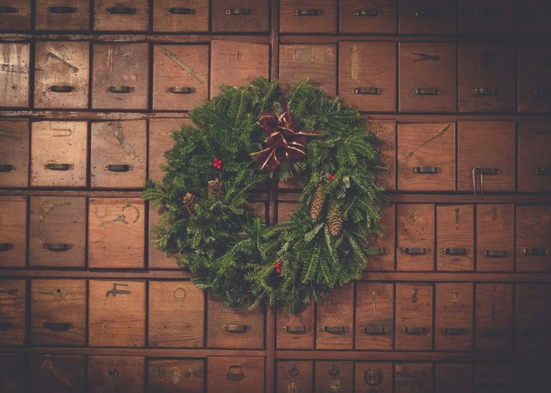 Image is of a holiday wreath hanging on antique wood drawers, concept of holiday markets and shopping in Nashville