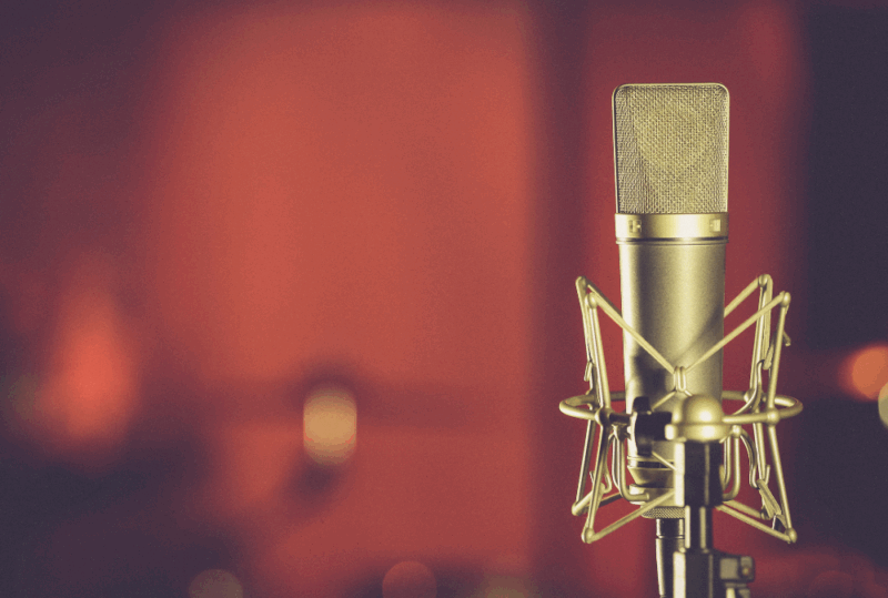 Image is of a microphone against a red background, concept of why Music Row is a great place to stay in Nashville