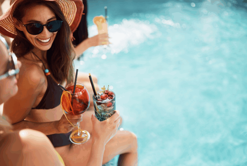 Image is of women enjoying cocktails by the pool, concept of things to do during a Nashville summer